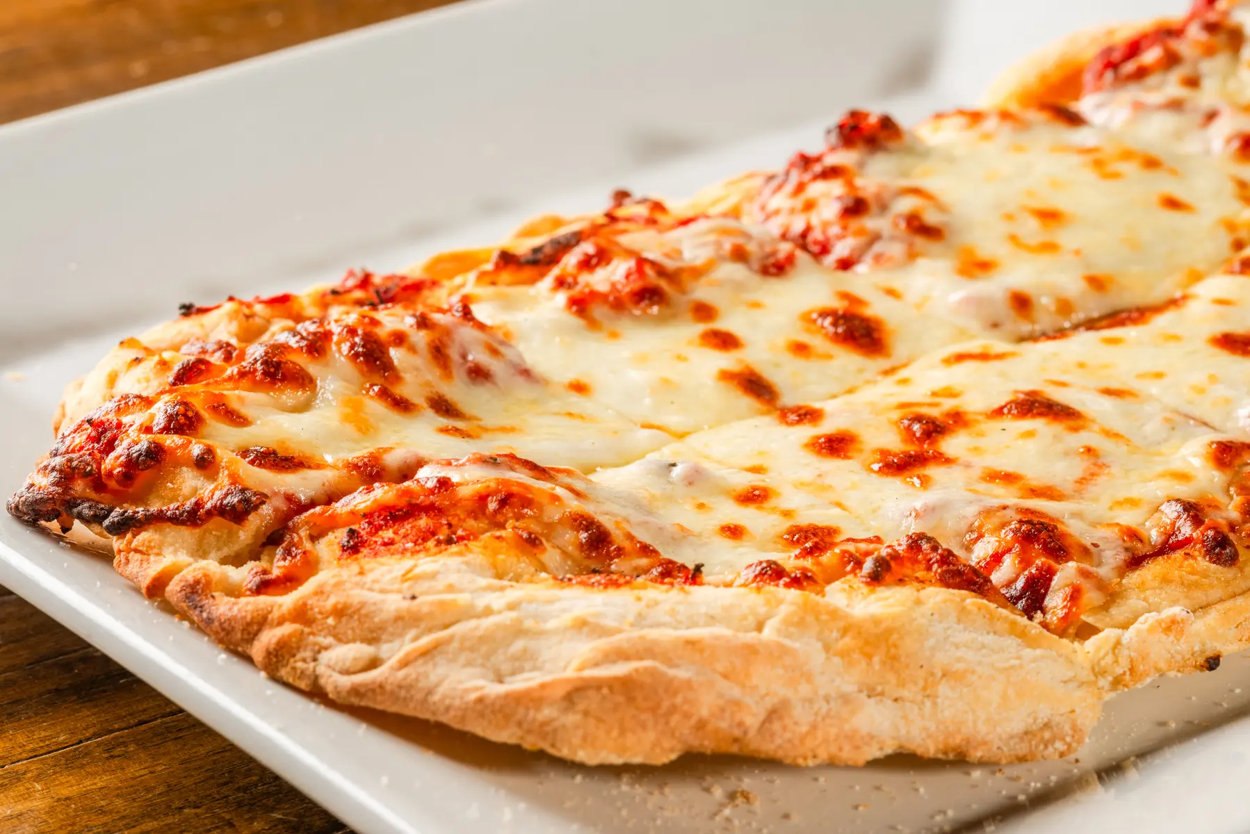 A close up of some cheese pizza on a plate