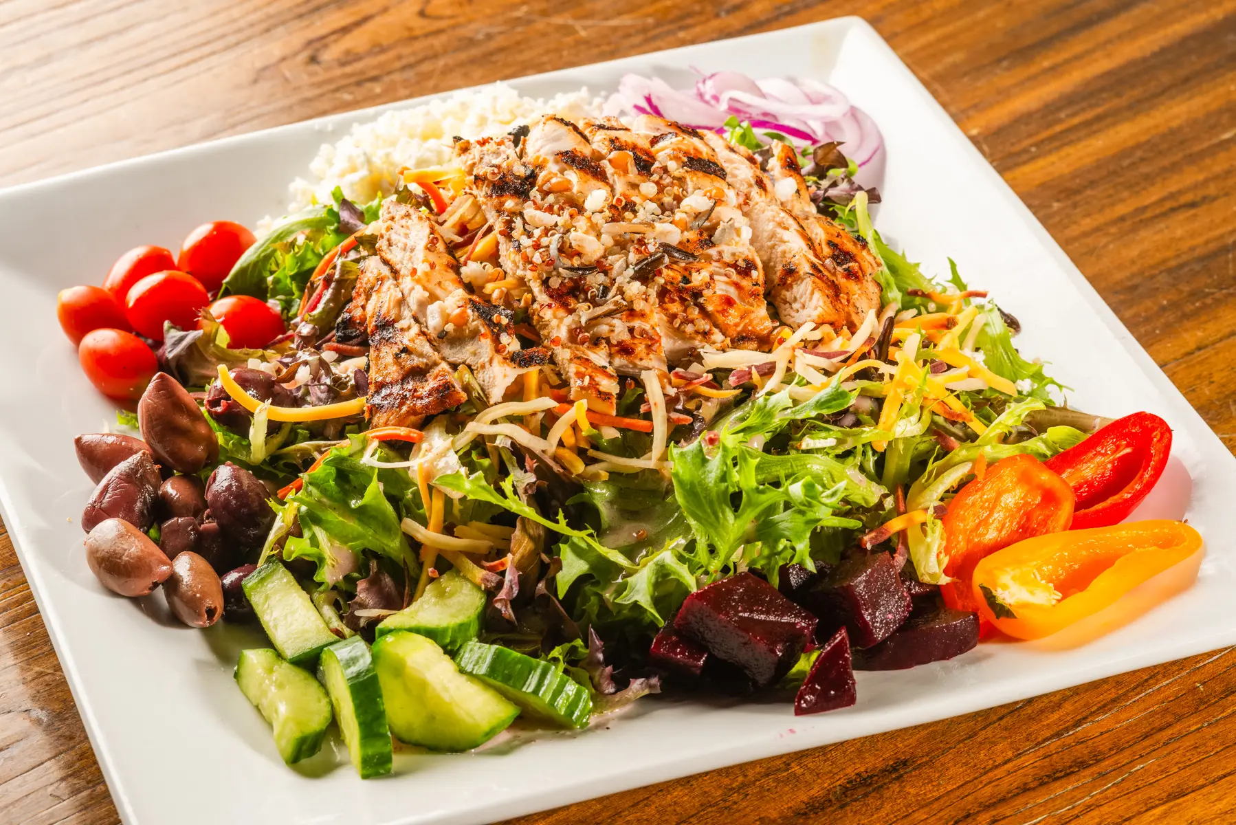 A plate of salad with dressing on top.