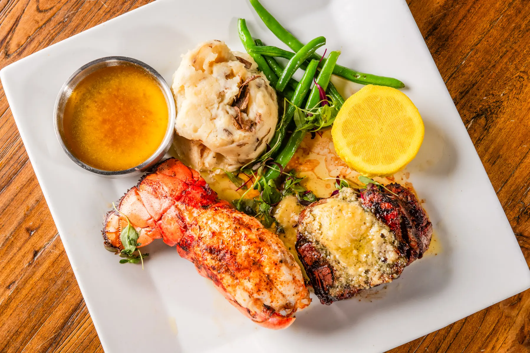 A plate of food with lobster, broccoli and asparagus.